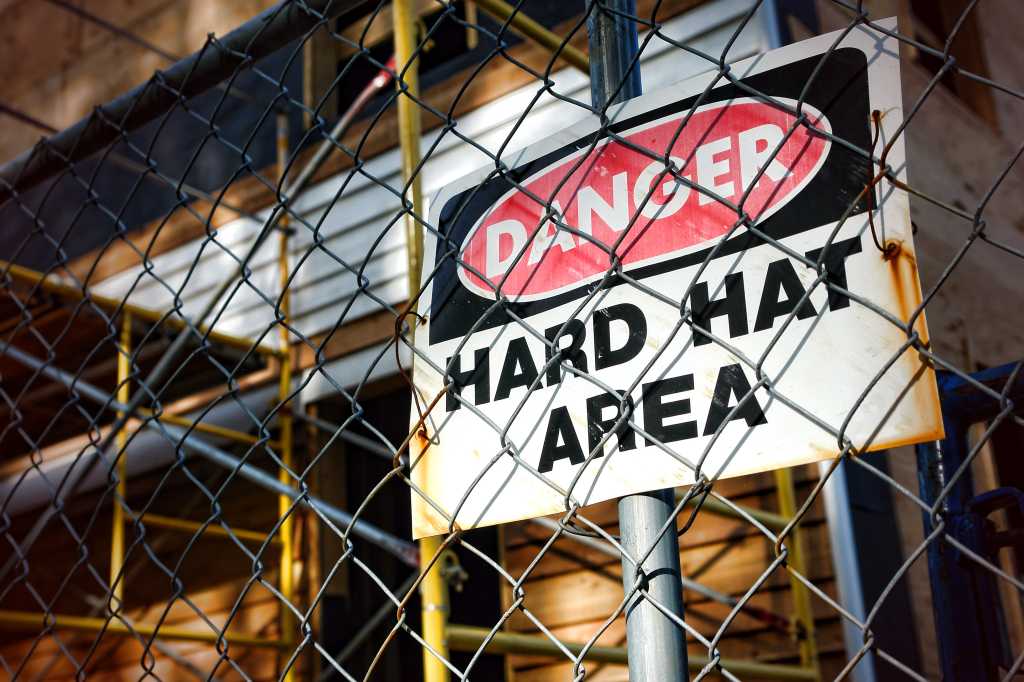 3604732-0-47300500-1742379659-shutterstock_77002051-100963133-orig-1 shutterstock 77002051 Danger hard hat area safety warning sign chain link fence construction site