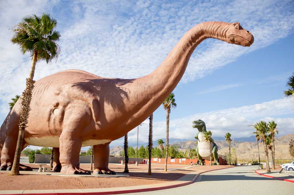 3829619-0-77542500-1740154576-shutterstock_1591493512-100937965-orig-1 shutterstock 1591493512 dinosaur roadside attraction brontosaurus T Rex clouds blue sky