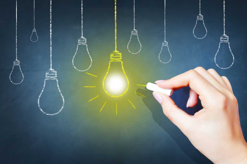 3847131-0-33962800-1742374915-shutterstock_258097682-1 A hand draws a series of hanging lightbulbs and one of them is bright yellow.
