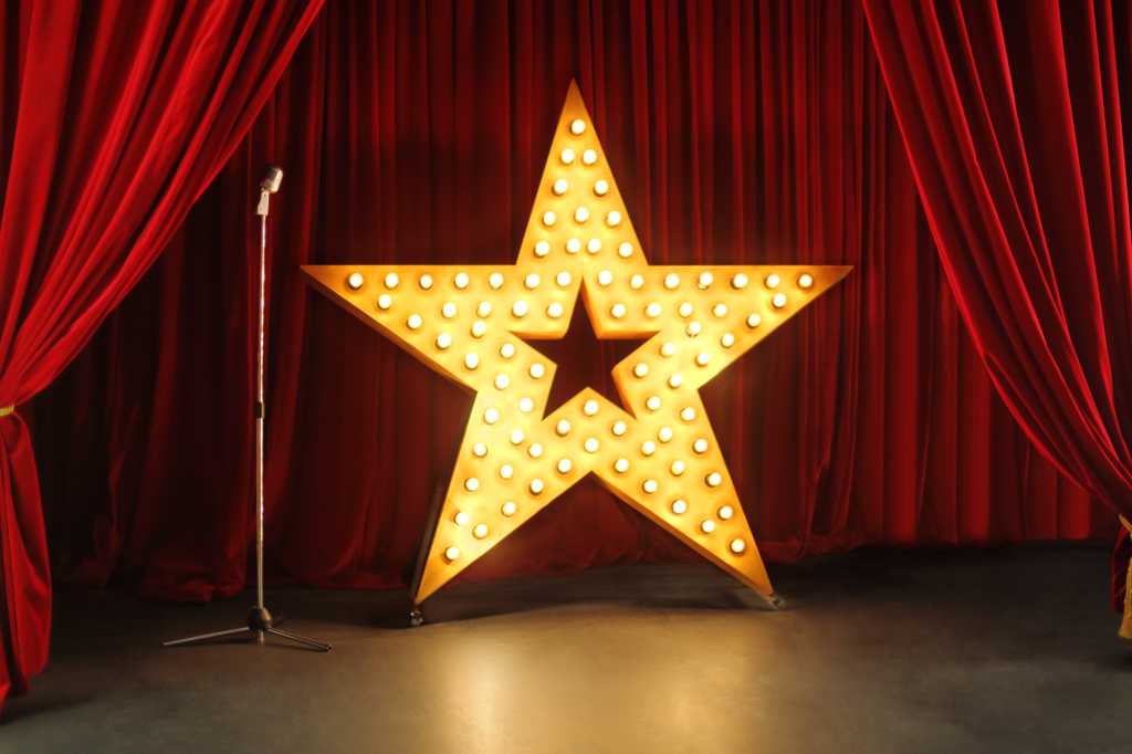 shutterstock_218547988-100961470-orig-1 shutterstock 218547988 retro stage with red curtains standing mic and giant gold star with lights