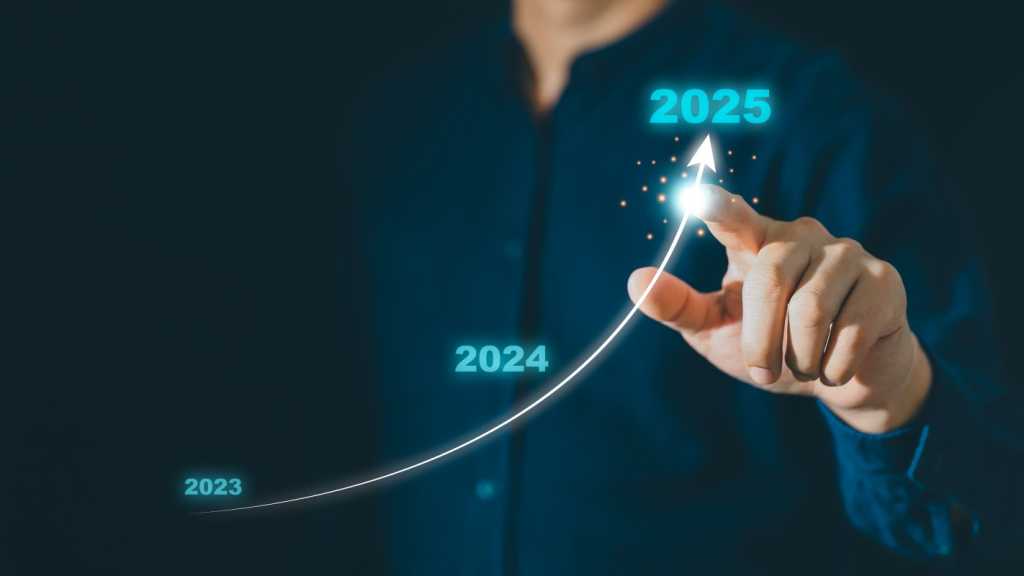 3856449-0-75863600-1743203270-to2025-1 A man holding out his index finger pointing at an arrow curving upward. Along the line of the arrow are the numbers 2023, 2024 and 2025.