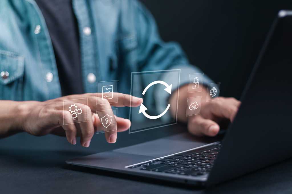 3952899-0-87339300-1743627135-shutterstock_2440894365-1 Person at laptop keyboard shown updating software.