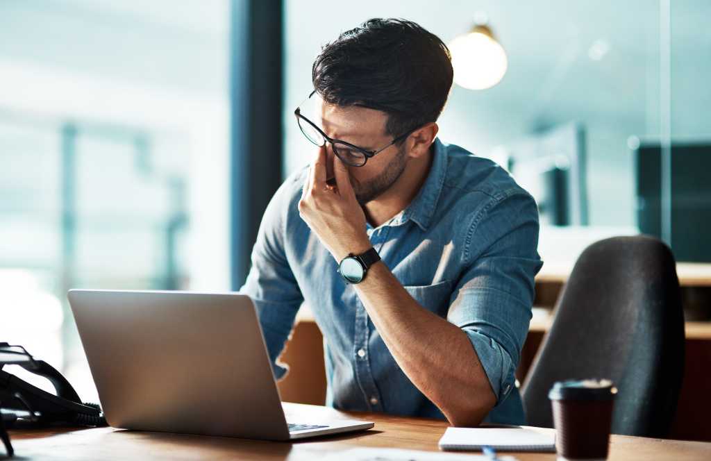 3956574-0-85760200-1744102883-shutterstock_2186538179-1 Stressed, tired and frustrated business man with headache at night from burnout or making mistake on laptop. Overworked creative entrepreneur failing to meet late office deadline or working overtime
