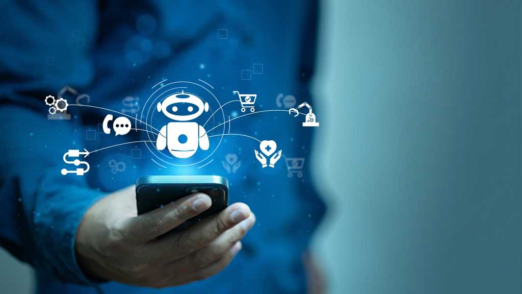 4003335-0-38701100-1750151070-shutterstock_2572652201-1 A man in a blue shirt interacts with an AI agent using a mobile device.