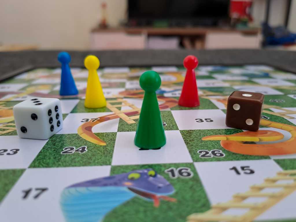 4006181-0-35956300-1749805379-shutterstock_2264474179-1 A close-up view of the Snakes and Ladders board game.